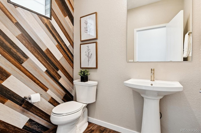 bathroom with hardwood / wood-style flooring, sink, and toilet