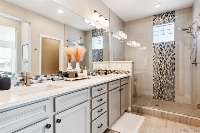 bathroom featuring vanity, decorative backsplash, and a shower with shower door