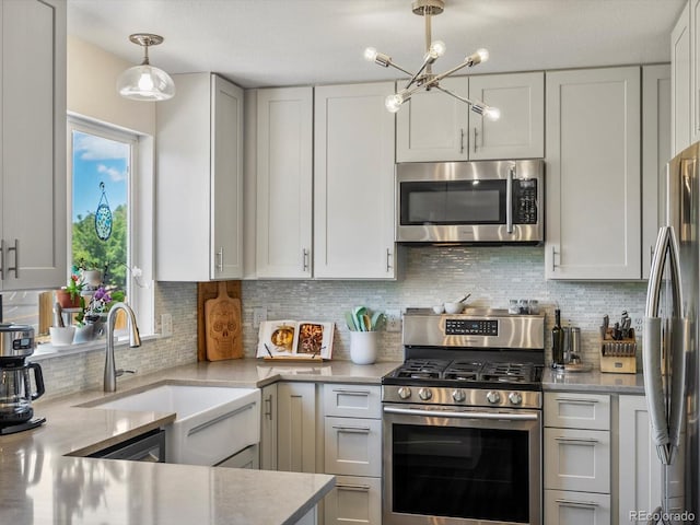 2006 E 97th Ave, Thornton, CO 80229 - kitchen featuring stainless steel appliances, a sink, a chandelier, tasteful backsplash, and hanging light fixtures