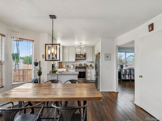 2006 E 97th Ave, Thornton, CO 80229 - dining space with plenty of natural light, dark wood-style floors, a chandelier, and baseboards