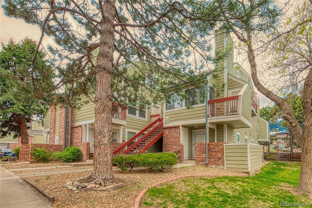 919 S Dawson Way Unit 17, Aurora, CO 80012 - view of front of house with brick siding, stairs, a balcony, and a chimney