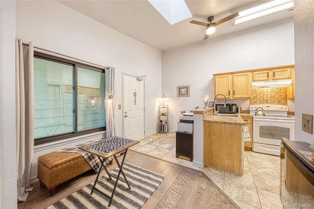 919 S Dawson Way Unit 17, Aurora, CO 80012 - kitchen with white electric range, under cabinet range hood, a skylight, a peninsula, and ceiling fan