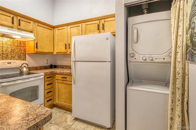 919 S Dawson Way Unit 17, Aurora, CO 80012 - kitchen with white appliances, stacked washer and clothes dryer, under cabinet range hood, and light tile patterned flooring