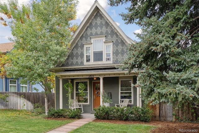 view of front of property with covered porch and a front yard