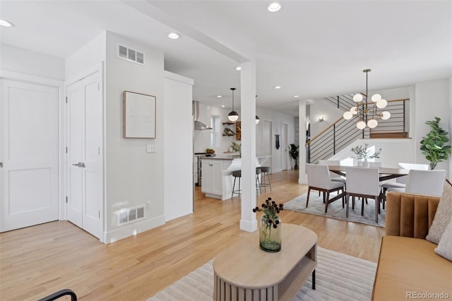 living room with an inviting chandelier and light hardwood / wood-style floors