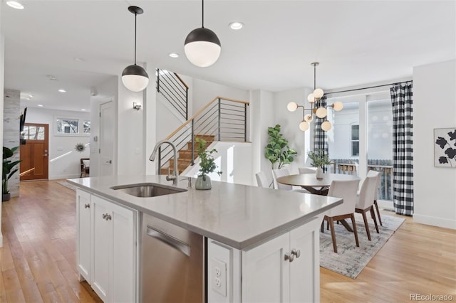 kitchen featuring sink, hanging light fixtures, and white cabinets