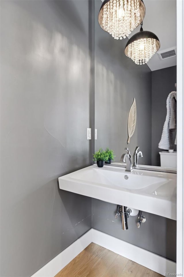 bathroom featuring hardwood / wood-style floors and a notable chandelier