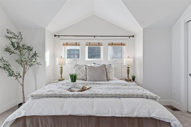 bedroom with lofted ceiling and light colored carpet