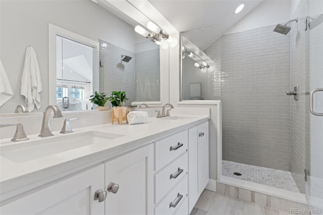 bathroom featuring a shower with door, vanity, and lofted ceiling