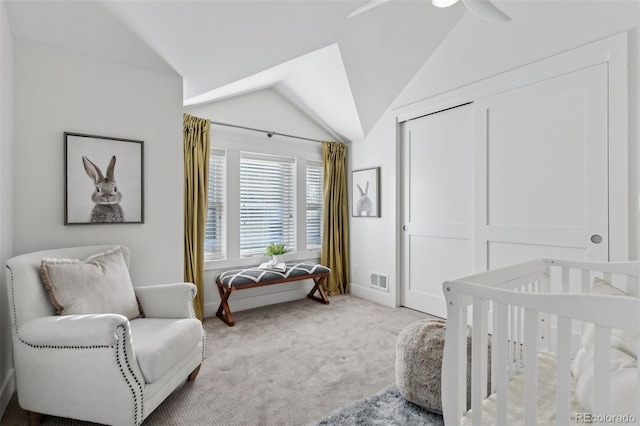 carpeted bedroom with ceiling fan, lofted ceiling, and a closet