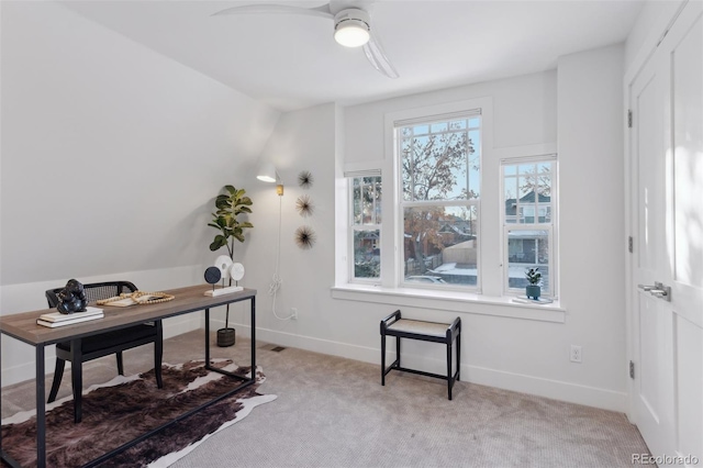 carpeted home office featuring ceiling fan