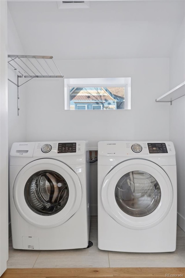 clothes washing area with washing machine and dryer