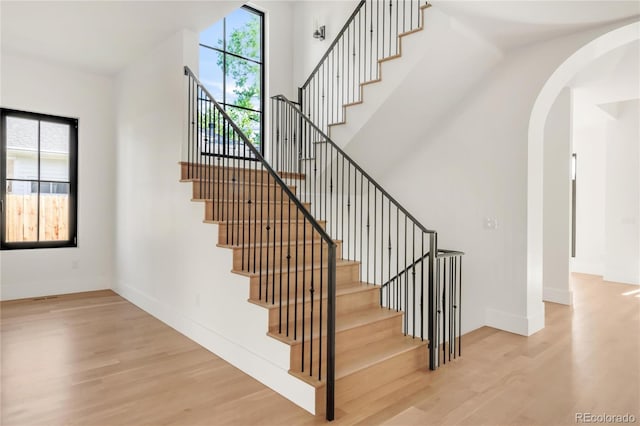 4452 Xavier St, Denver, CO 80212 - stairs with plenty of natural light, wood finished floors, and arched walkways