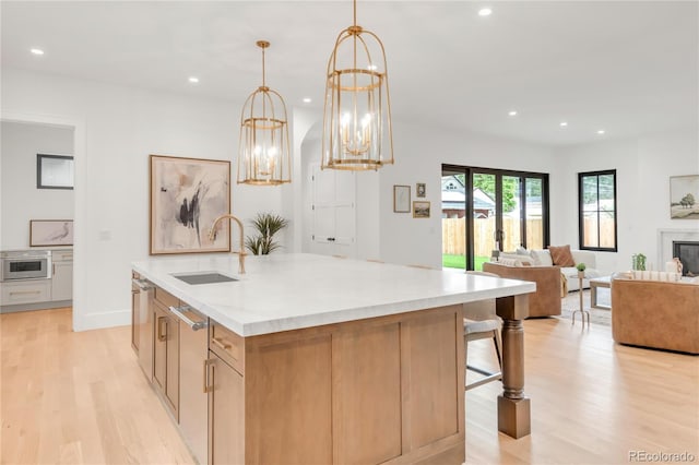 4452 Xavier St, Denver, CO 80212 - kitchen featuring light wood-style floors, recessed lighting, open floor plan, an island with sink, and light countertops