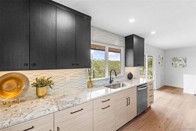 kitchen with light wood-type flooring, sink, backsplash, dishwasher, and light stone countertops