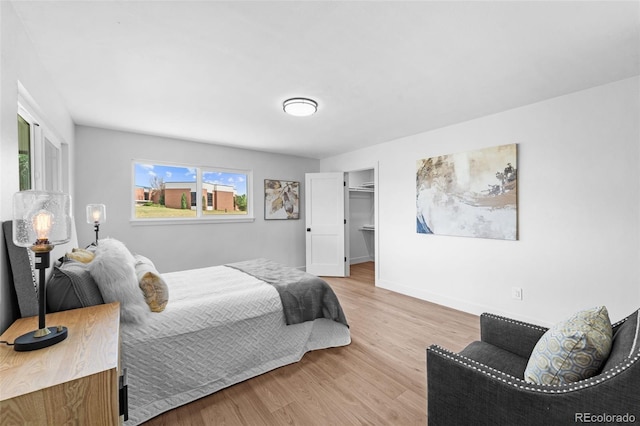 bedroom featuring light hardwood / wood-style floors, a spacious closet, and a closet