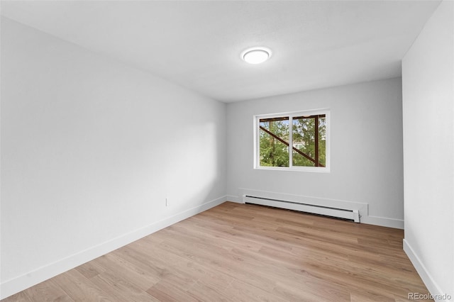 empty room with light hardwood / wood-style floors and a baseboard radiator