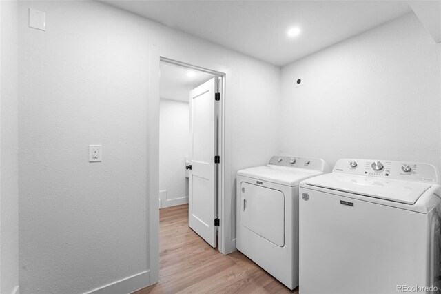 laundry area with light wood-type flooring and separate washer and dryer