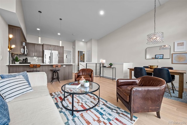 3480 E 31st Ave, Denver, CO 80205 - living area featuring light wood-style flooring, lofted ceiling, recessed lighting, and a chandelier