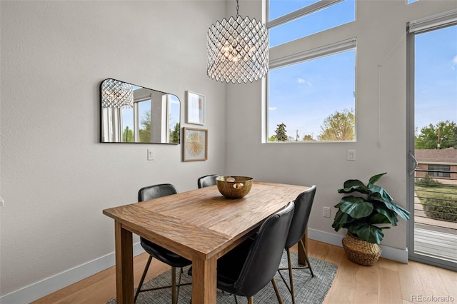 3480 E 31st Ave, Denver, CO 80205 - dining space with baseboards, a chandelier, and light wood-style flooring