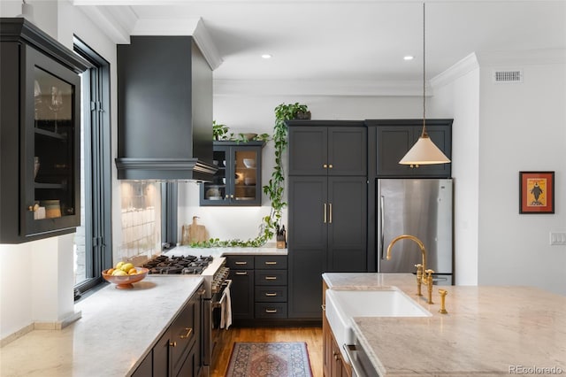3424 W 31st Ave, Denver, CO 80211 - kitchen featuring appliances with stainless steel finishes, island range hood, a sink, glass insert cabinets, and light stone counters