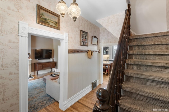 3424 W 31st Ave, Denver, CO 80211 - stairs with wood finished floors, wallpapered walls, a chandelier, and baseboards