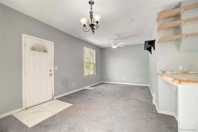 unfurnished dining area with ceiling fan with notable chandelier, a textured ceiling, and carpet