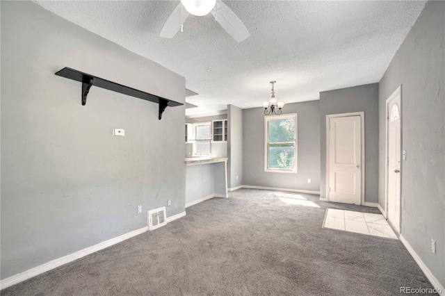 interior space with a textured ceiling and ceiling fan with notable chandelier