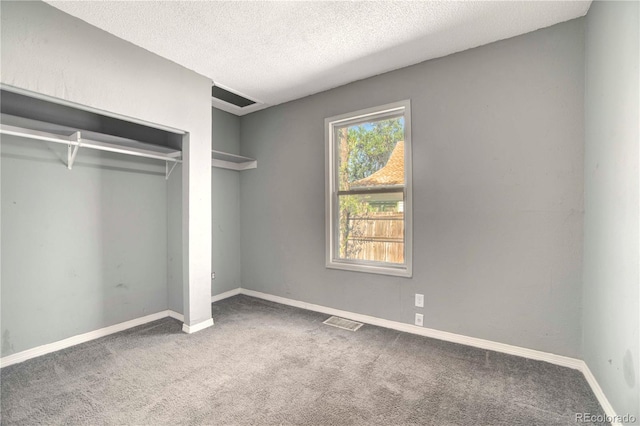 unfurnished bedroom with a closet, carpet flooring, and a textured ceiling