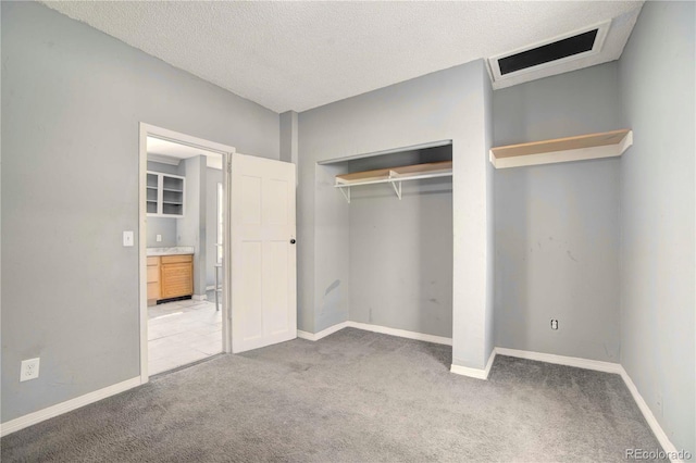 unfurnished bedroom with a textured ceiling, light colored carpet, and a closet