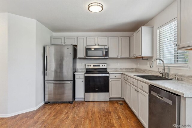 5441 Lynx St, Frederick, CO 80504 - kitchen featuring stainless steel appliances, a sink, light countertops, wood finished floors, and baseboards