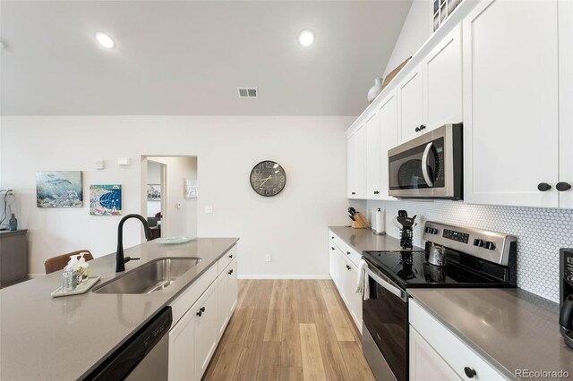 2078 Autumn Moon Dr Unit 3, Windsor, CO 80550 - kitchen with appliances with stainless steel finishes, white cabinets, light wood-type flooring, backsplash, and recessed lighting