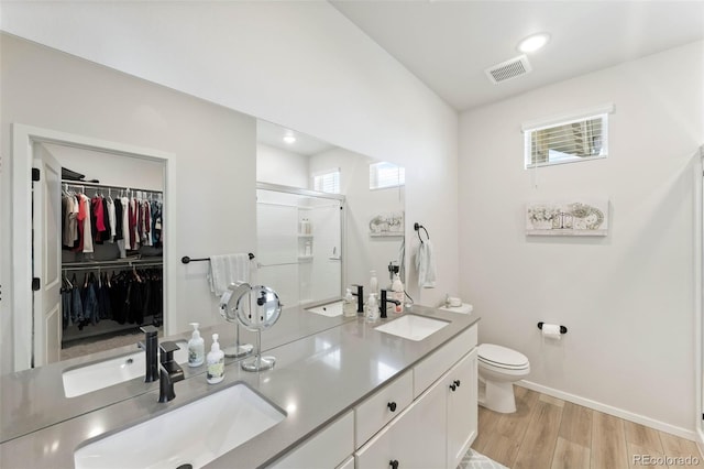 2078 Autumn Moon Dr Unit 3, Windsor, CO 80550 - full bath featuring double vanity, a shower stall, wood finished floors, and a walk in closet