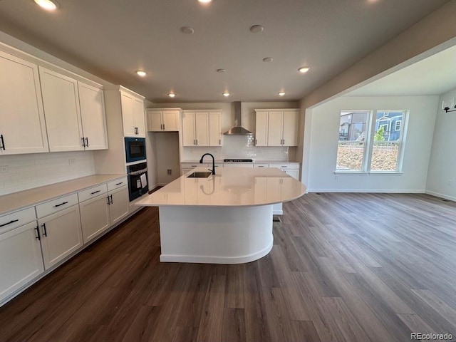 283 Wooten Ave, Brighton, CO 80601 - kitchen with wall chimney exhaust hood, white cabinets, dark wood-type flooring, and recessed lighting