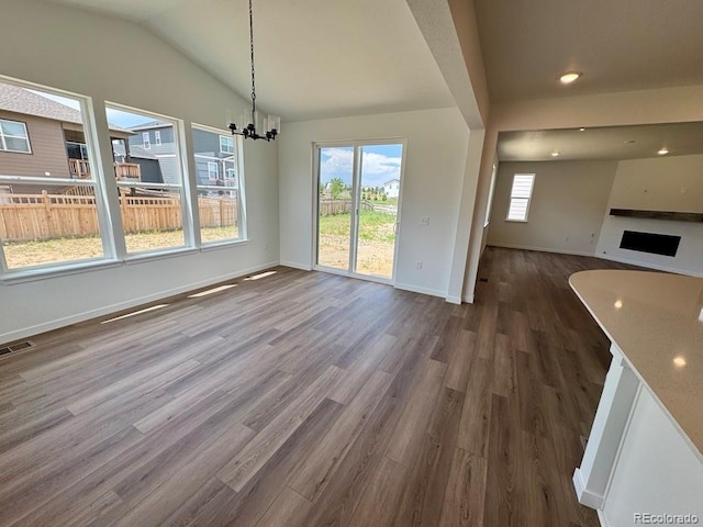 283 Wooten Ave, Brighton, CO 80601 - unfurnished dining area with dark wood-style flooring, vaulted ceiling, recessed lighting, and a chandelier