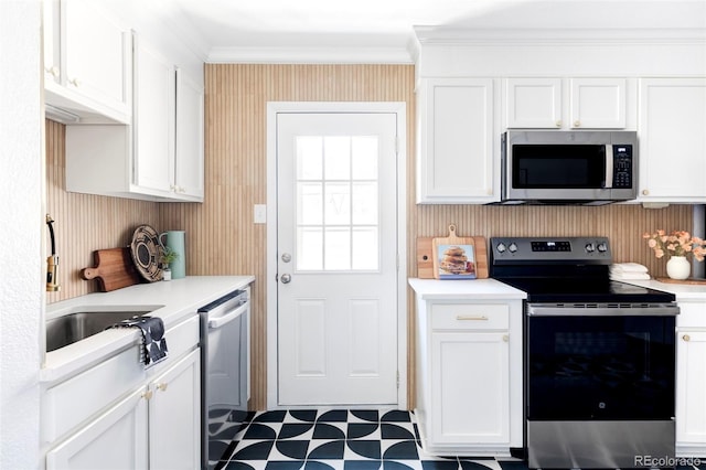 2313 S Race St Unit A, Denver, CO 80210 - kitchen featuring appliances with stainless steel finishes, crown molding, light countertops, white cabinetry, and wallpapered walls