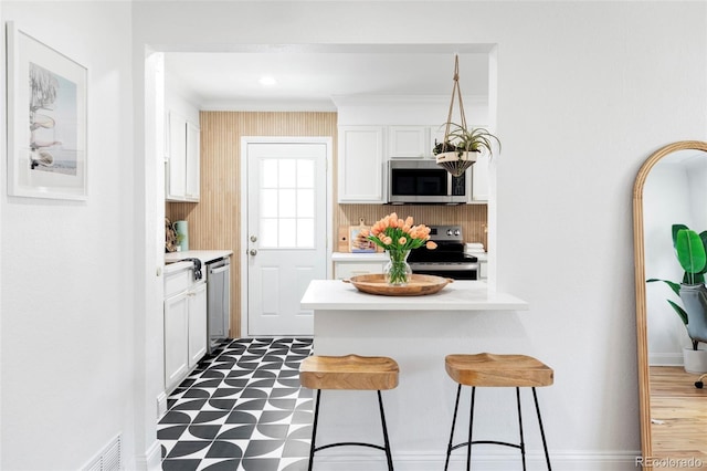 2313 S Race St Unit A, Denver, CO 80210 - kitchen featuring stainless steel appliances, a kitchen breakfast bar, dark floors, white cabinets, and light countertops