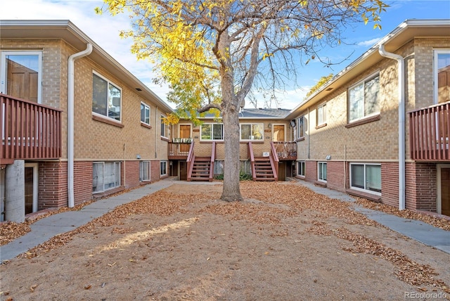 2313 S Race St Unit A, Denver, CO 80210 - rear view of house featuring stairway, brick siding, and a wooden deck