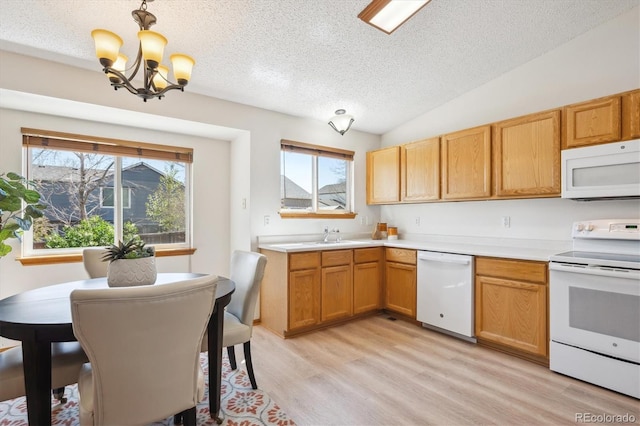 kitchen featuring an inviting chandelier, white appliances, a textured ceiling, and a wealth of natural light