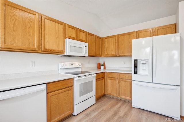 kitchen with light countertops, light wood finished floors, vaulted ceiling, and white appliances