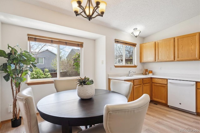 dining space featuring a textured ceiling, light wood finished floors, and a notable chandelier