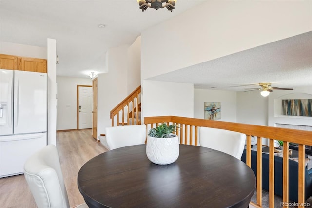 dining room with stairway, a ceiling fan, and light wood-style flooring
