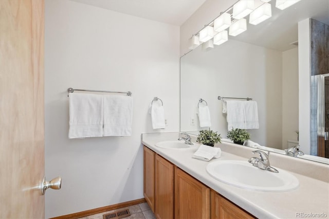 bathroom featuring double vanity, tile patterned floors, visible vents, and a sink
