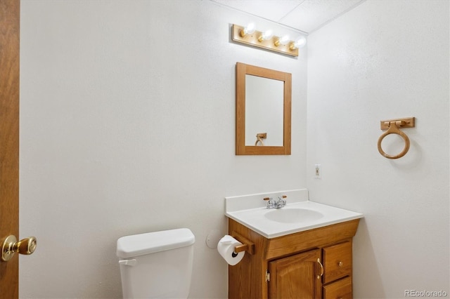 half bathroom featuring vanity and toilet