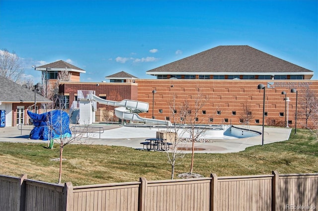view of yard featuring fence, a patio, and a community pool