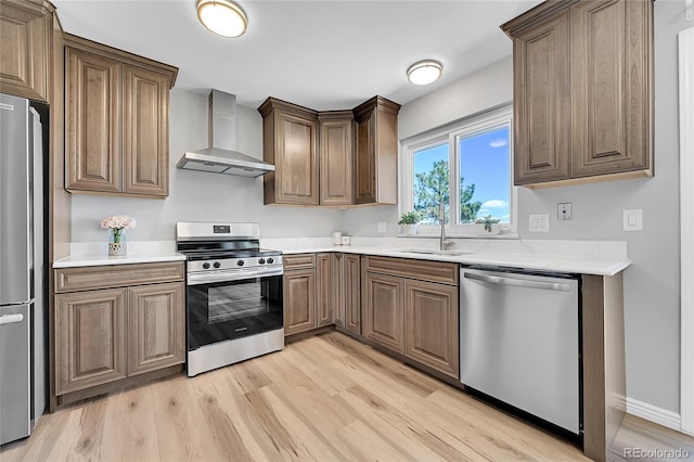 19155 E Kansas Dr, Aurora, CO 80017 - kitchen featuring stainless steel appliances, wall chimney exhaust hood, a sink, and light wood finished floors