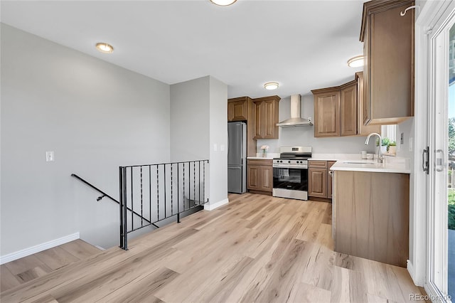 19155 E Kansas Dr, Aurora, CO 80017 - kitchen with stainless steel appliances, a sink, wall chimney range hood, light wood-style floors, and light countertops