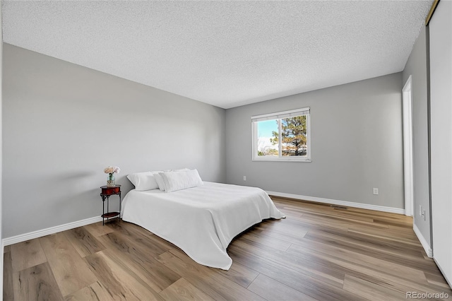 19155 E Kansas Dr, Aurora, CO 80017 - bedroom with wood finished floors, a textured ceiling, and baseboards