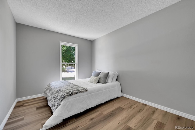 19155 E Kansas Dr, Aurora, CO 80017 - bedroom featuring wood finished floors, baseboards, and a textured ceiling