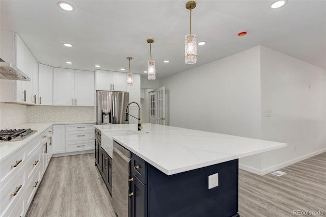 kitchen featuring white cabinets, light wood-style flooring, tasteful backsplash, and stainless steel appliances